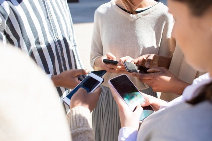 Cropped view of young people using smartphones oyun bağımlılığı